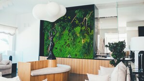 A modern living room with a curved seating area, a large wall-mounted aquarium, and a minimalist design.