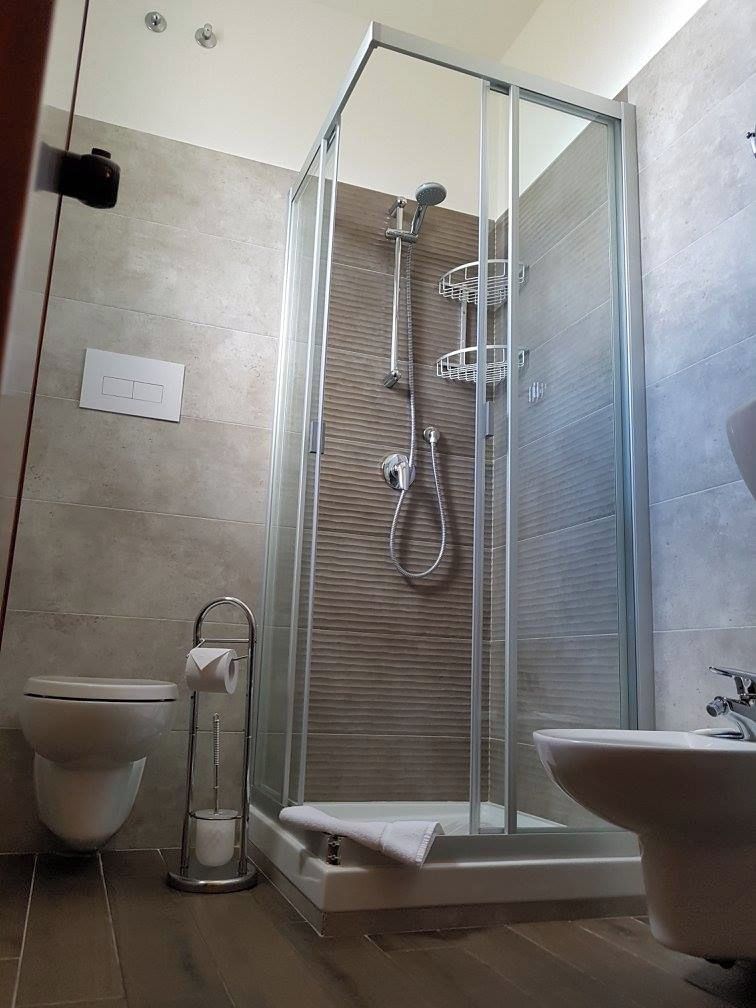 Un baño moderno con ducha envuelta en vidrio, inodoro y lavabo.