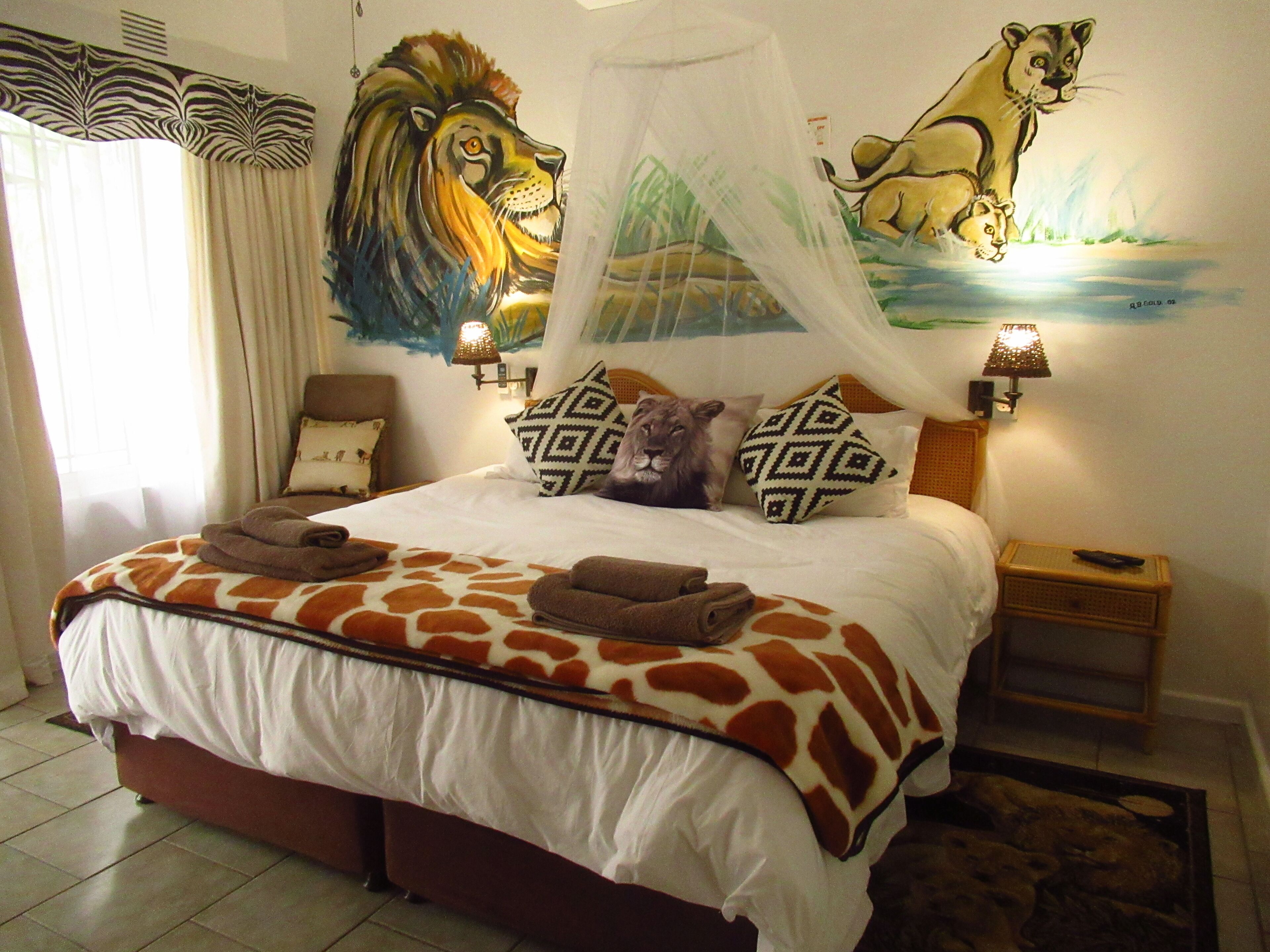 Una camera da letto con un letto, un murale raffigurante un leone, una tenda a righe zebrate e un comodino con una lampada.