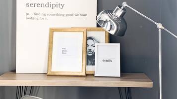Een moderne werkruimte met een groot gepresenteerd poster, een bureaulamp en ingelijste foto's.