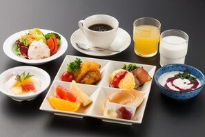 A variety of food items including a salad, soup, and sandwiches, along with cups of coffee and juice.