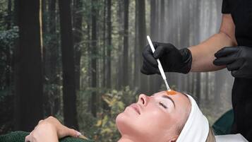 A person lying on a medical examination bed with a forest background.