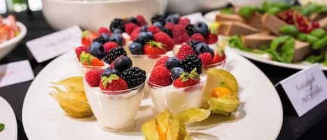 A dessert display with fruit-topped desserts on white plates.