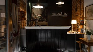 A reception area with a black counter, a vintage telephone, and a wall-mounted sign reading "Good Time Apart Hotel." - Loft Piotrkowska by Good Time (Lodz)