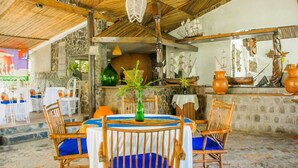 Un restaurant doté de meubles en bois et d’un décor rustique, avec un mur en pierre et des éléments de décoration sur le thème des navires.