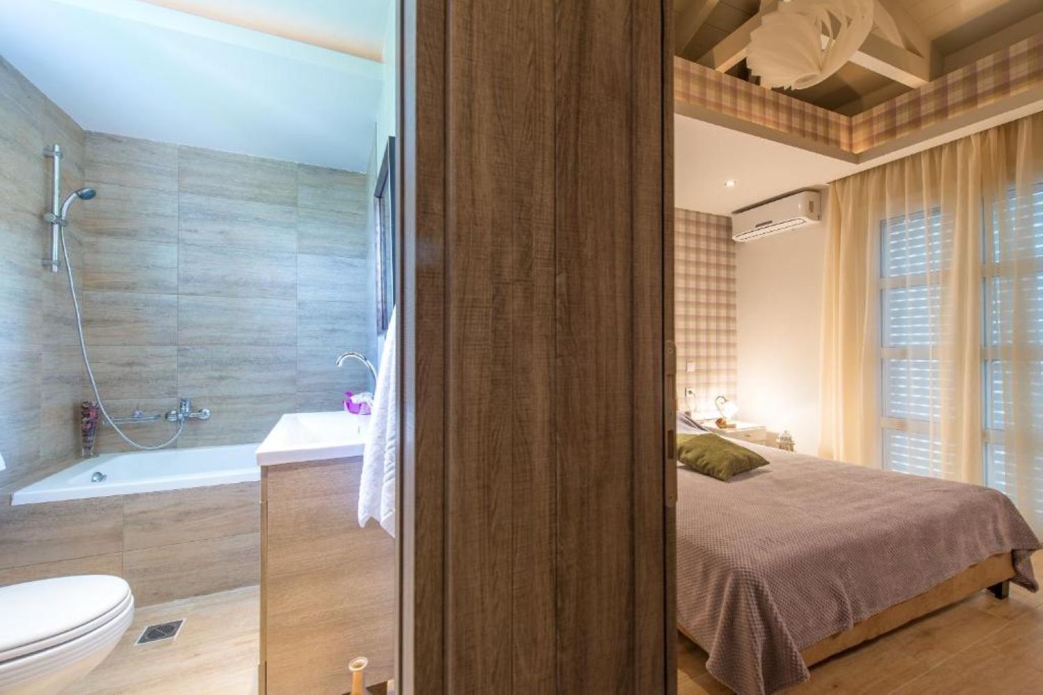 A modern bathroom with a shower, sink, and toilet.