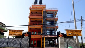 Een meerlaags gebouw met borden waarop staat dat het een appartementenhotel is, genaamd Park Treasure Pvt. Ltd.