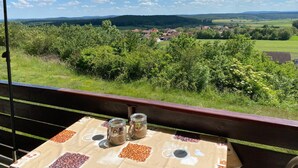 Una mesa con frascos de café y vista a un pueblo desde un balcón.