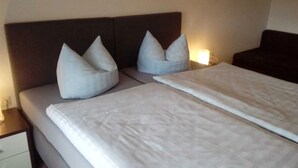 Una cama bien hecha con dos almohadas y un edredón blanco.