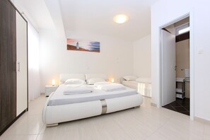 A modern bedroom with a large bed, bedside tables, a nightstand, and a painting on the wall. - Villa Visnjik (Zadar)