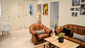 A modern living room with leather armchairs, a wooden coffee table, and a glass dining table. - Cosy S3 At Sidi Bou Said Village (Sidi Bou Said)