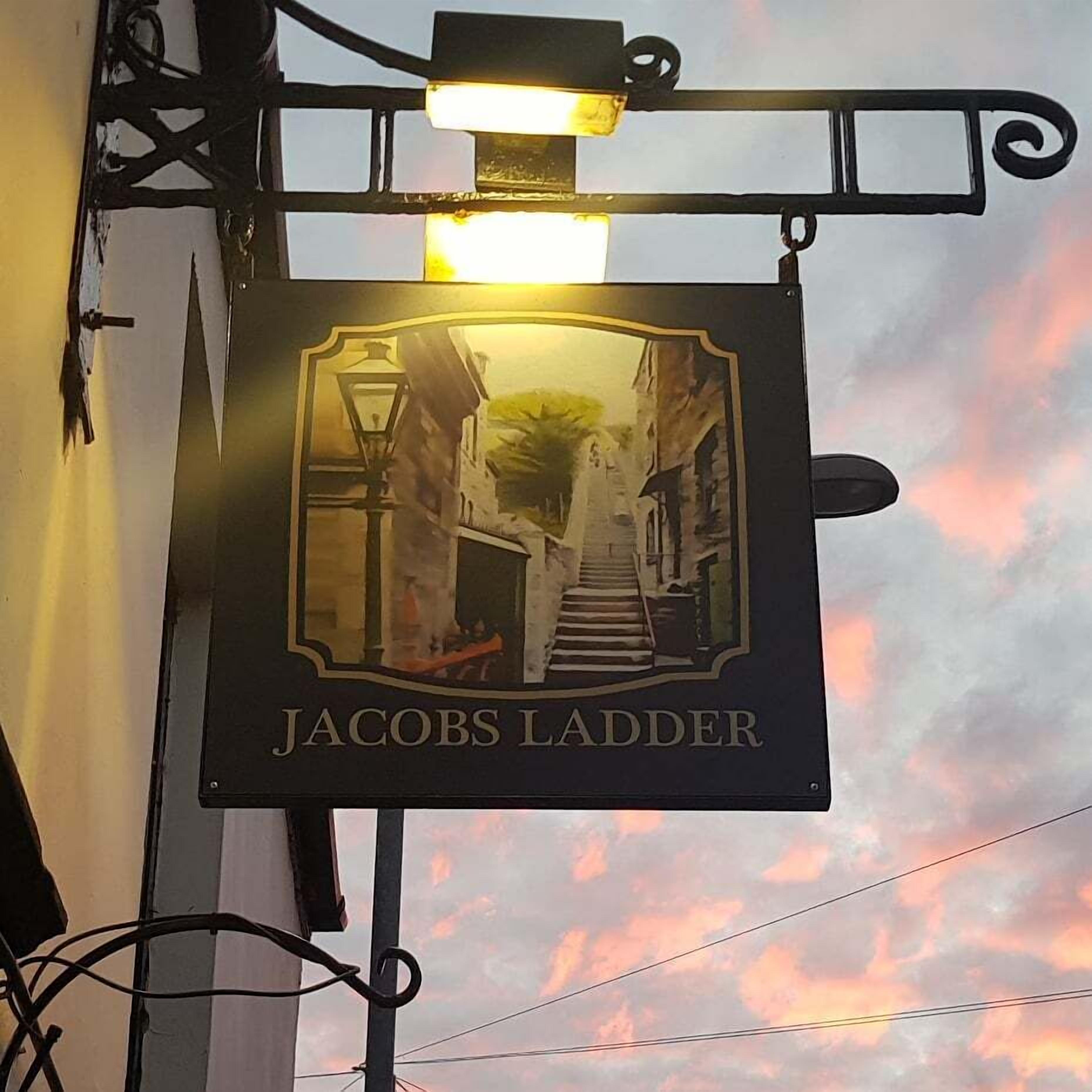 Ein Pub-Schild mit einer Treppe und einem Laternenpfahl, betitelt "Jacob's Ladder".