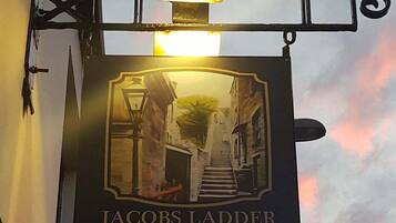 Un letrero de pub con una escalera y un farol, que dice 'Jacob's Ladder'.
