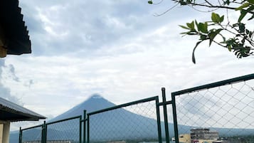 A fenced outdoor area with a view of a mountain in the distance.
