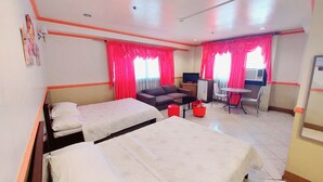 A hotel room with two beds, a sofa, a small table, a TV, and a desk with a chair. - Tabaco Gardenia Hotel (Tabaco City)