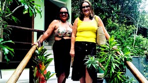 Deux personnes se tiennent sur un escalier, de part et d’autre, on peut voir des plantes en pot.