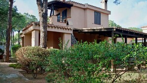 A two-story house with a covered patio and a garden area. - Villa Corallo (Pula)