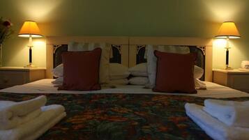 A hotel room with a bed, two nightstands, two lamps, and a floral bedspread.