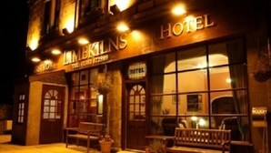 Un hôtel appelé « LIMELINS HOTEL », doté d’une façade classique, de grandes fenêtres et d’un espace extérieur aménagé pour s’asseoir.