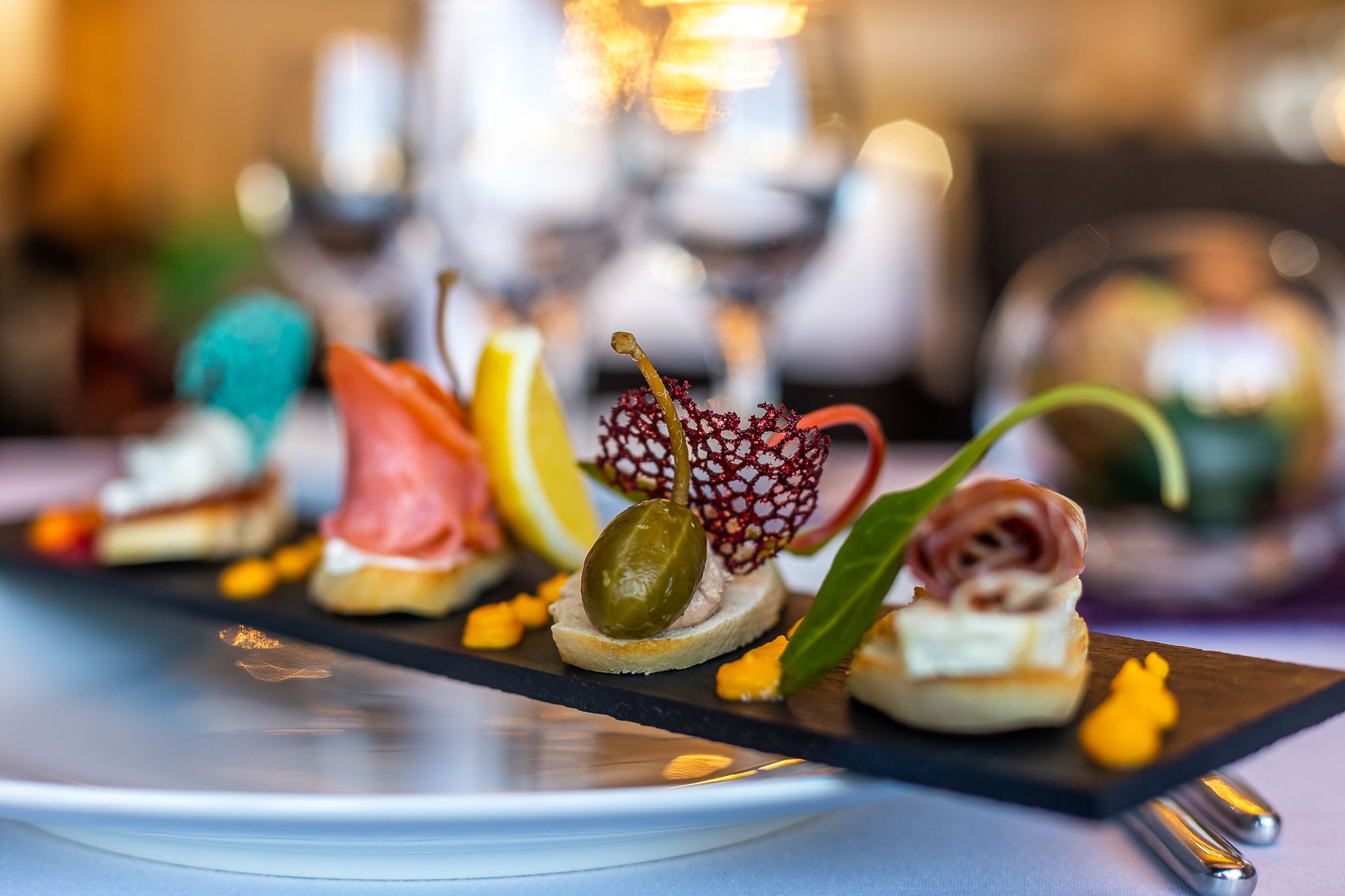 A variety of appetizers on a black slate board.