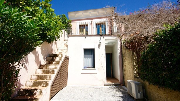 A narrow, stone staircase leading to a white building with a balcony. - Casa Assumptha Pt (Olbia)
