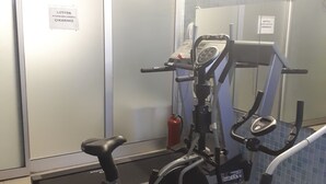 Un área de fitness con una máquina elíptica, una bicicleta estática y una cinta de correr.
