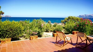 A terrace with two folding chairs overlooking a coastal view. - Villa Magica (Olbia)