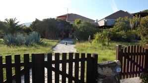 Una entrada cerrada a una zona residencial, con un camino de piedra que lleva a casas.