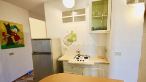 Una cocina con refrigerador, estufa y alacenas.