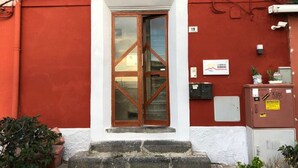 A red building with a white-framed door, numbered 19, and a small step leading up to it. - La Dimora dei Borboni (Portici)
