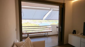 A room with a sliding glass door leading to a balcony with a view of a pool and greenery.