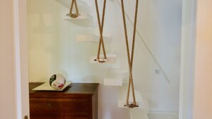 A staircase with a wooden handrail and a white wall. - Casa Turchese (Olbia)