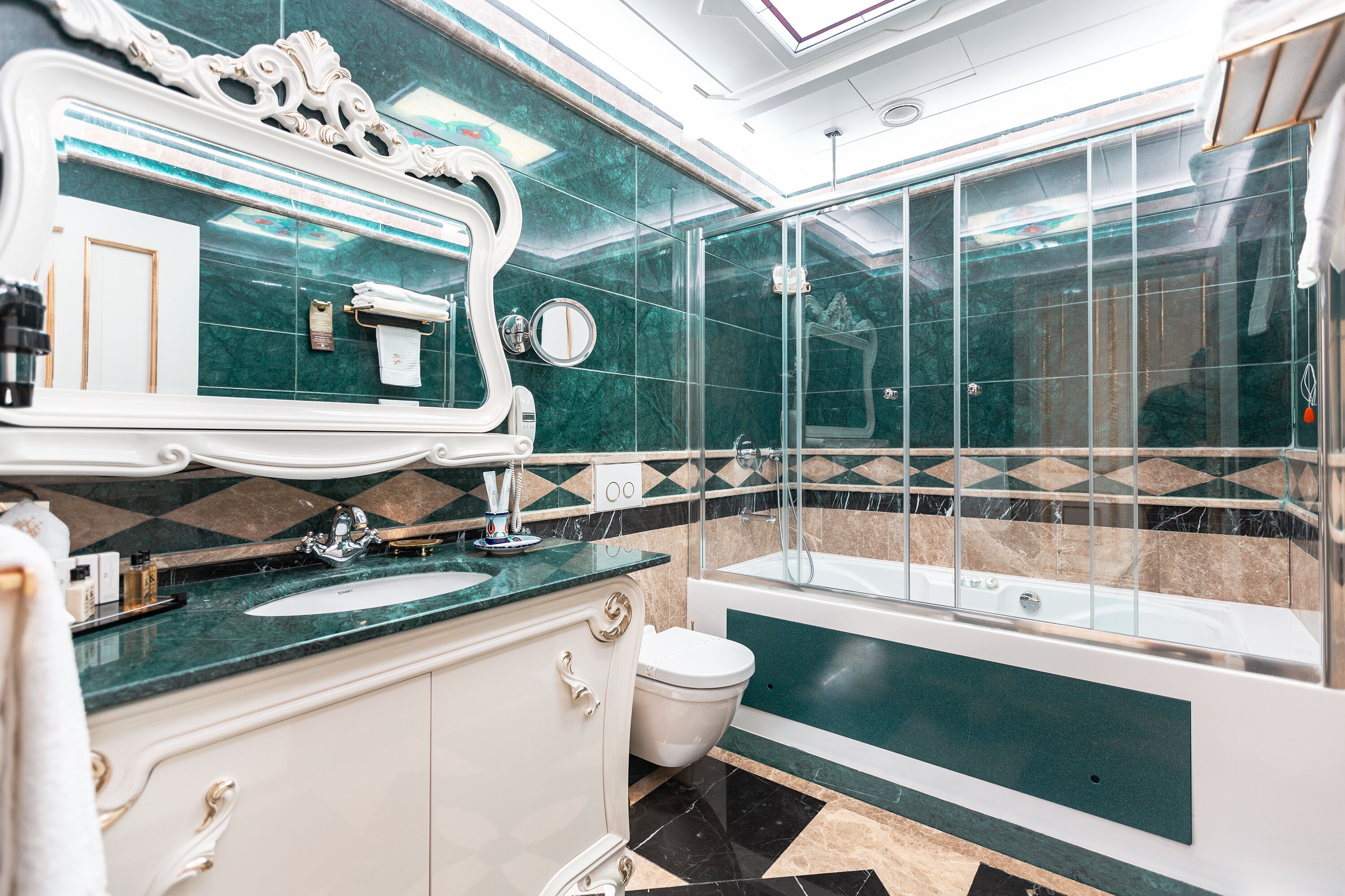 A bathroom with a marble vanity, a bathtub, and a glass-enclosed shower.