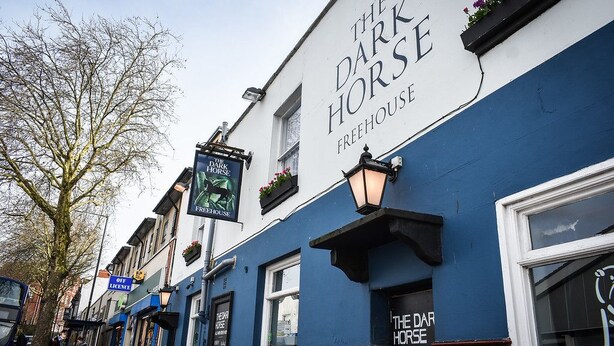 Un edificio con un letrero que dice "The Dark Horse Freehouse".