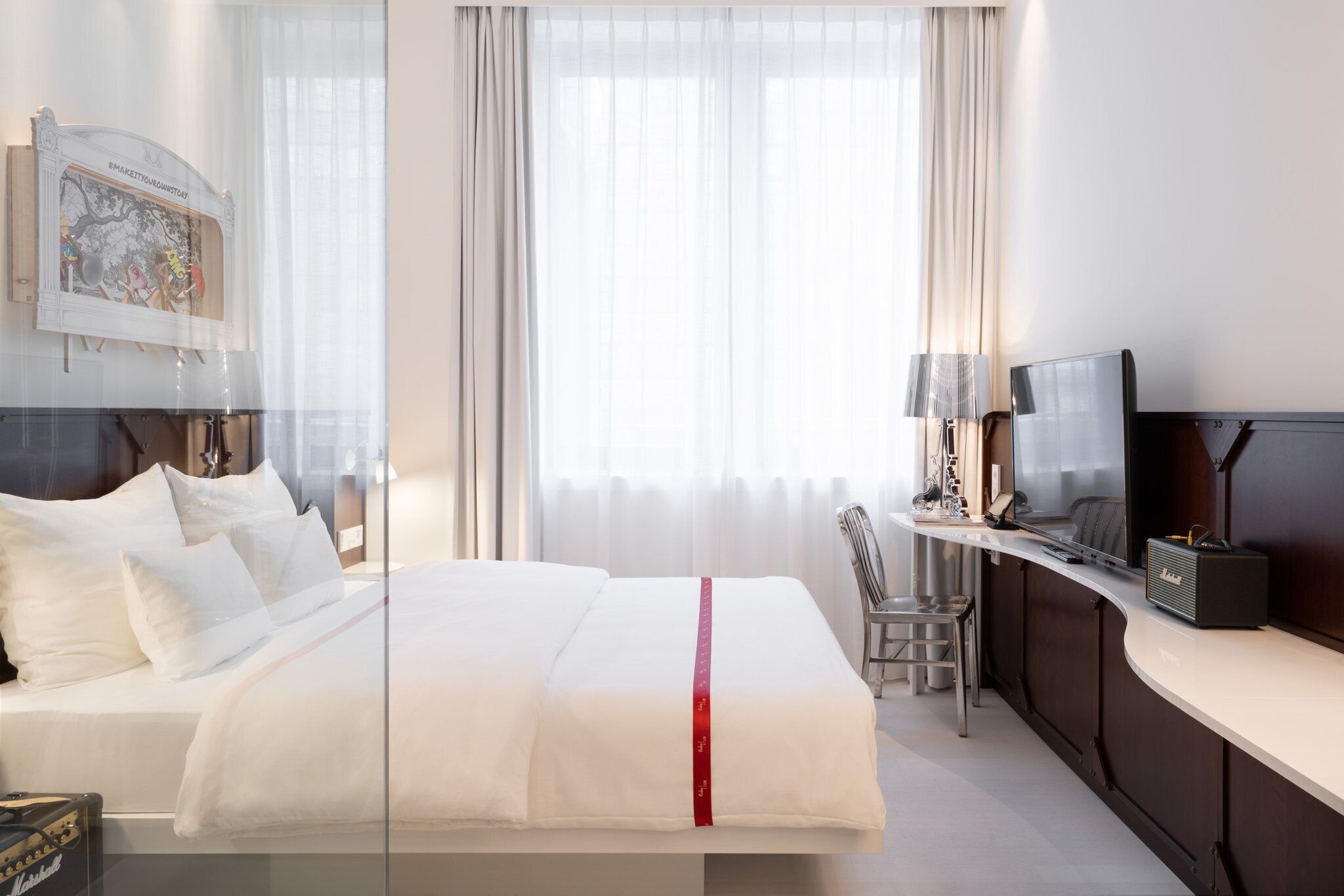 Una habitación de hotel con una cama, televisión, escritorio y una silla.