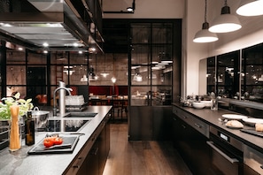 Una cocina moderna con electrodomésticos de acero inoxidable, una isla grande e iluminación colgante.