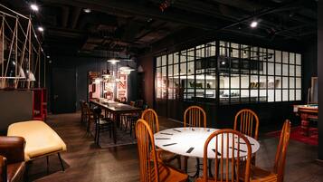 A modern dining area with a round table, wooden chairs, and pendant lighting.