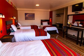 A hotel room with three beds, a desk, and a TV. - Hotel Tierra Inka Sacred Valley (Ollantaytambo)