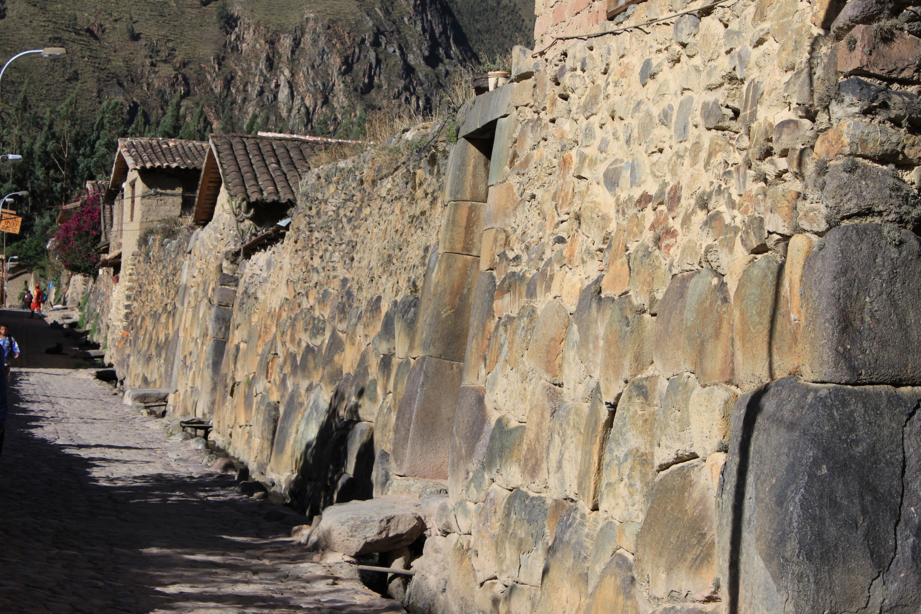 Un muro de piedra con un estrecho sendero a su lado.