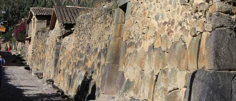 Un muro de piedra con un estrecho sendero a su lado.