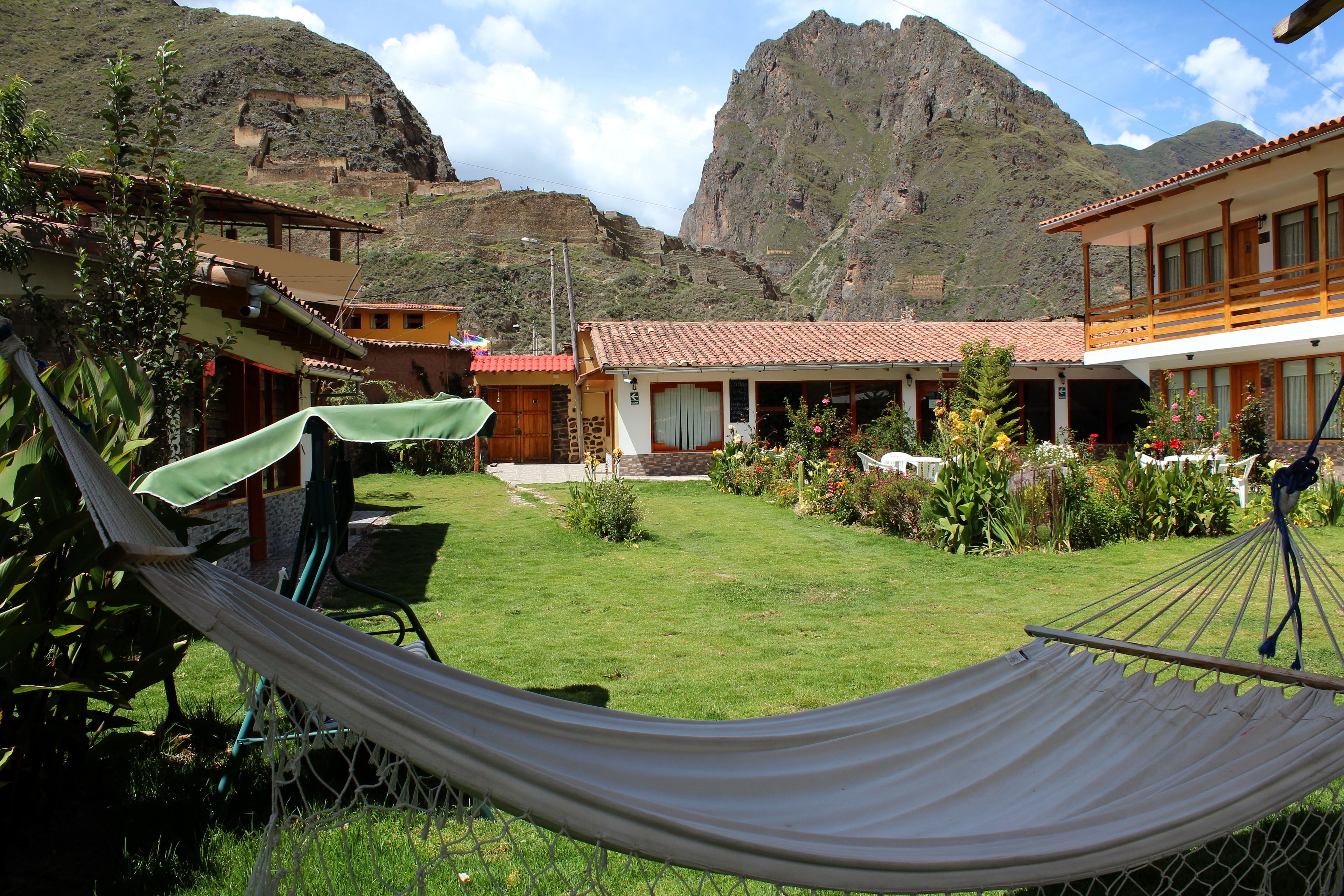A hotel with a garden, a hammock, and a mountain view.