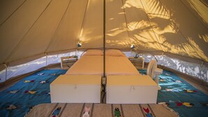 A tent with a bed, two fans, and a patterned carpet. - Todos Santos Hostel (Todos Santos)