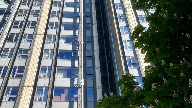 Un immeuble moderne et imposant, doté de nombreux étages et d’une structure verticale centrale.
