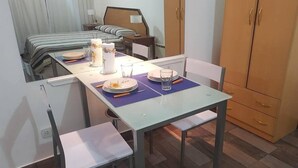 A small, neatly arranged room with a bed, a table set for two, and a wardrobe. - 1 Ambiente en Recoleta (Buenos Aires)