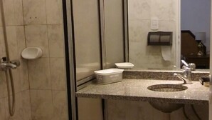 A bathroom with a shower, toilet, sink, and a mirror. - 1 Ambiente en Recoleta (Buenos Aires)