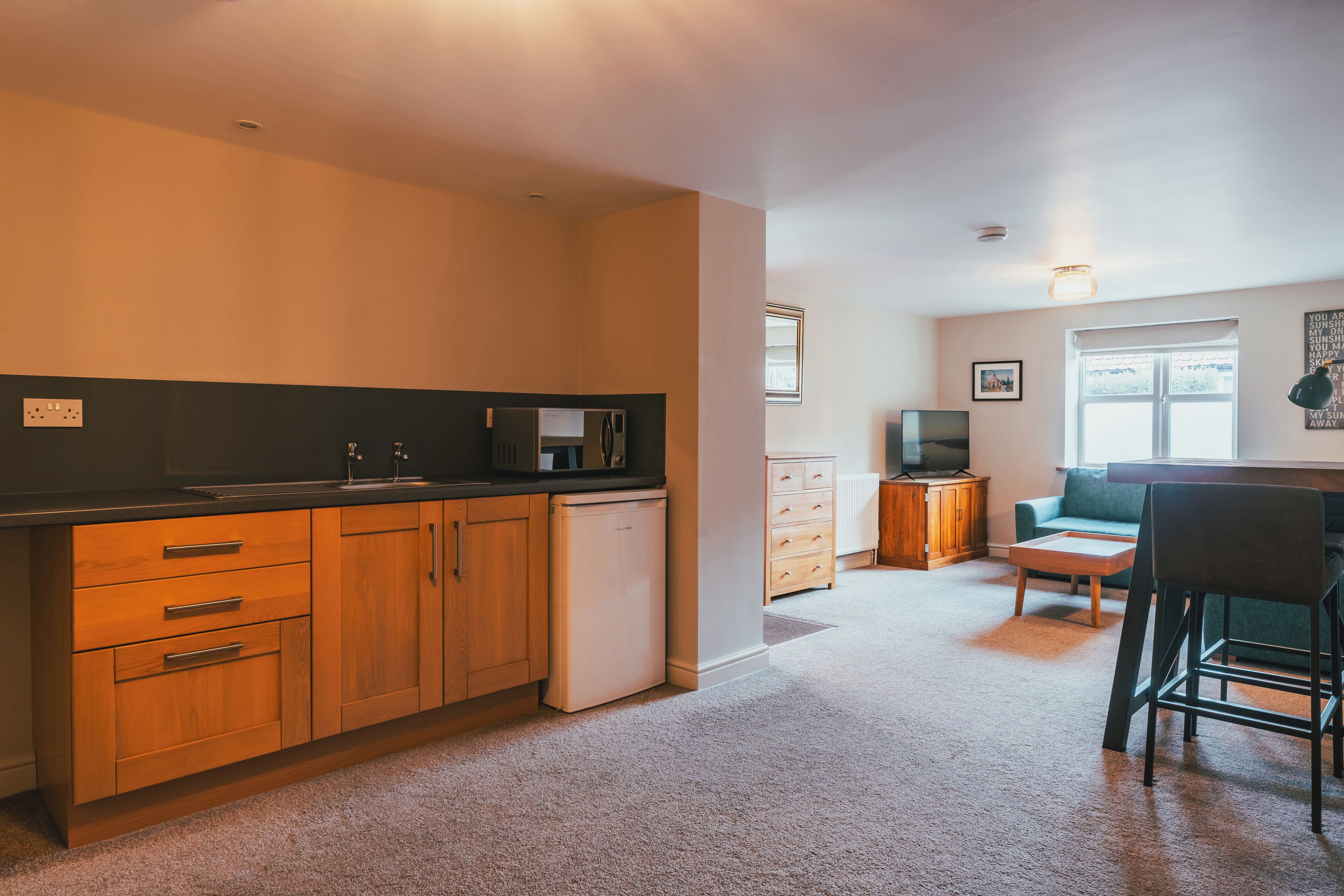 A compact living space with a kitchenette, a dining area, and a seating area.