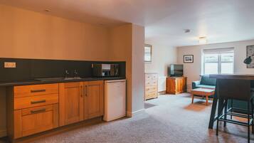 A compact living space with a kitchenette, a dining area, and a seating area.
