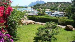 A coastal view with a marina, boats, and lush greenery. - Villa Sara (Olbia)