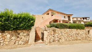 Un bâtiment aux murs de pierre, avec un escalier menant à un deuxième étage.