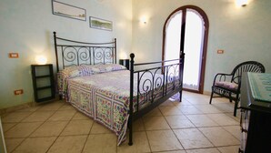Une chambre à coucher avec un lit, une chaise, un bureau et une porte.
